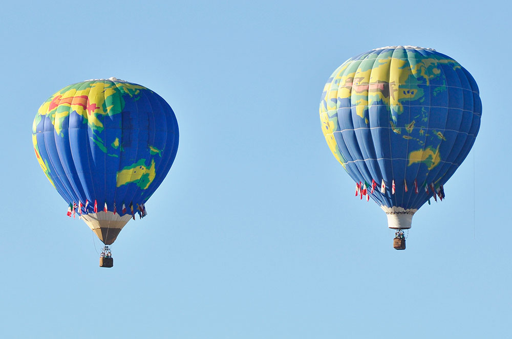 Two Hot Air Balloons Flying Against Beautiful Blue Sky
